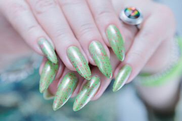 Female hand with long nails and light green manicure