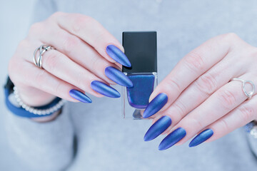 Woman's beautiful hand with long nails and blue and purple nail polish