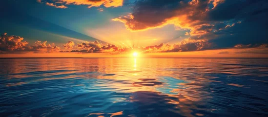 Selbstklebende Fototapeten Sunset over water in golden and blue hues. © 2rogan