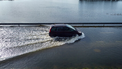 Samochody na zalanej wodą drodze po powodzi. 
