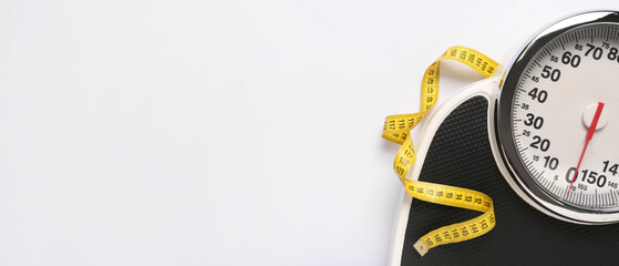 Scales and measuring tape on white background with space for text. Weight loss concept