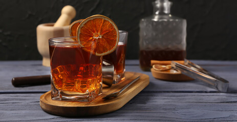 Glass of cold Old Fashioned Cocktail on wooden table