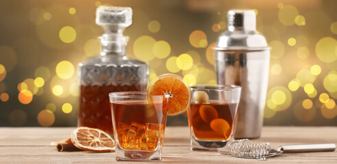 Glasses of cold Old Fashioned Cocktail on wooden table in bar
