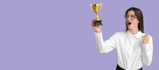 Happy young businesswoman with trophy cup on lilac background with space for text