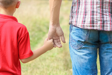 A Hands of happy child and parent on nature in the park family concept