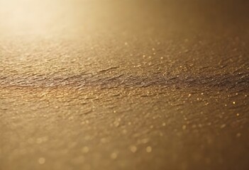 A golden textured surface with a subtle pattern and light reflections