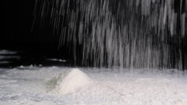 I sprinkle flour on a black background, in a large layer. Baking flour.