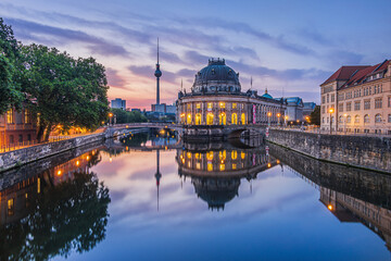 Historical buildings on Museum Island in Berlin in the morning at sunrise. River Spree with reflections. Television tower in the background of the skyline of the capital of Germany - obrazy, fototapety, plakaty