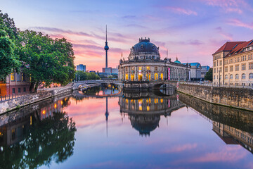 Sunrise in Berlin. Skyline in the center of the capital of Germany. Historical buildings on the Museum Island and television tower with reflections on water surface from the Spree river - obrazy, fototapety, plakaty