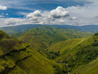 Tropical valley and green hill with river. Blue sky and clouds. Mindanao, Philippines.