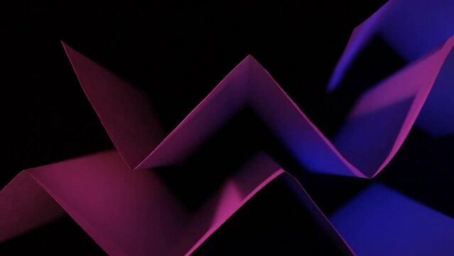 Papel reciclado de formas de vida sustentables,  doblado en &aacute;ngulo recto en forma de tri&aacute;ngulos, iluminado con luz lateral, presenta un dise&ntilde;o abstracto y geom&eacute;trico colorido con fondo negro.