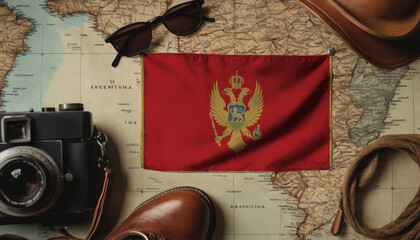 Montenegro flag lies on the map surrounded by camera, glasses, travel and tourism concept