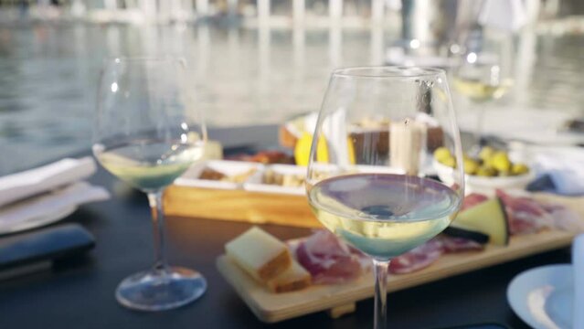 Amazing friends or couple aperitif time on the pool side of hotel resort, people tasting traditional Italian aperitif snacks and enjoying the view of luxury hotel backyard with large swimming pool