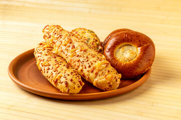 Fresh pastries on clay plate. With cheese, cottage cheese and ham. On wooden bamboo background
