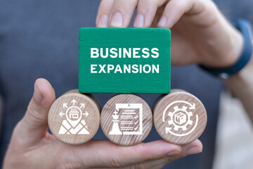 Man holding blocks sees inscription: BUSINESS EXPANSION. Web business expansion such as teamwork, sales, marketing, strategy, distribution network, franchise. Concept of business expansion.
