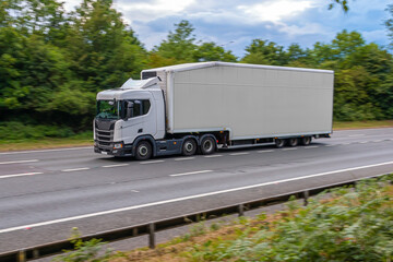 Fototapeta na wymiar White no name double decker lorry in motion on the motorway.