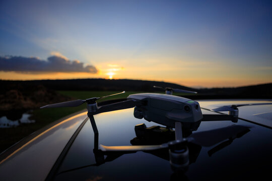 drone launch before field use on car hood during sunset