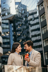 Two colleagues converse amidst urban architecture
