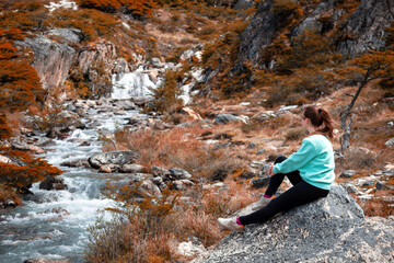 Mujer admirando la cascado y arroyo de los bosques patagónicos de Ushuaia, en Argentina