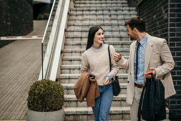 Businesswoman and man exchanging insights while strolling through the business district on their...