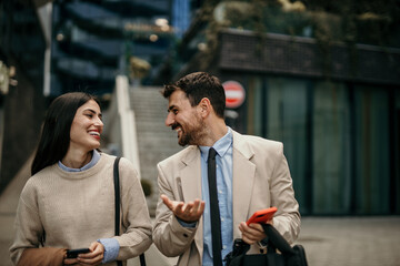 Two business partners in animated discussion during their daily walk to the office in the city