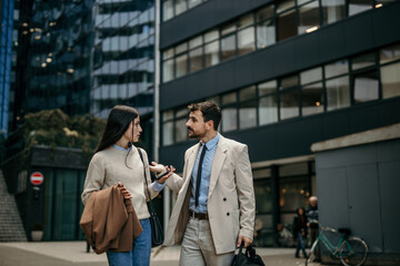 Successful team members exchange ideas on their way to work in the vibrant city center