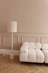 a light beige sofa and a table lamp as part of the interior