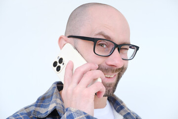 positive charming young man in glasses using modern phone with smile, highlighting role of gadgets...