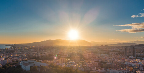 Sunset aerial view of Spain city with sun over mountain