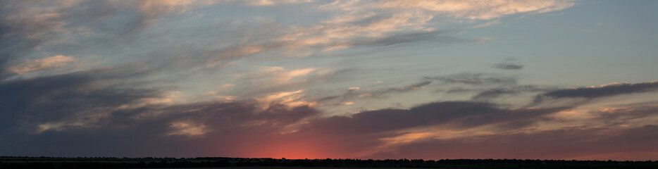 Landscape at sunset. Tragic gloomy sky. Panorama. Crimson twilight.