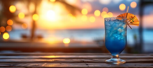 Blue hawaiian cocktail in tropical setting with blurred beach background and copy space