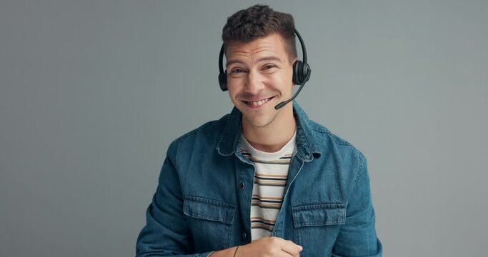 Call center, face and happy man consulting in studio for about us, customer service or faq on grey background. Telemarketing, virtual assistant or lead generation consultant with pov help or advice
