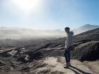 A person with the view of dried lava terrain from active volcano in Bromo Tengger Semeru National Park, East Java, Indonesia.