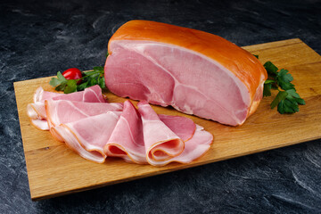 Traditional South Tyrolean farmer's ham sliced and in one piece offered with parsley and tomatoes...