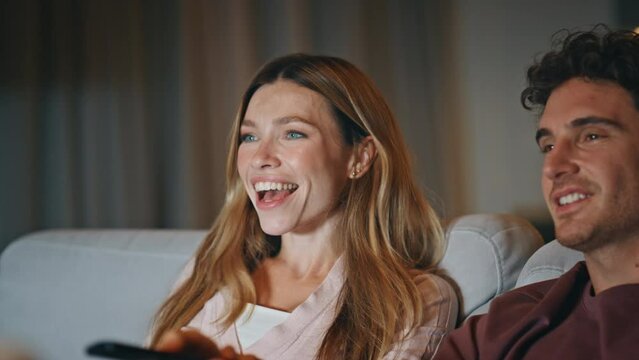 Overjoyed family watching tv sitting at cozy living room late evening closeup