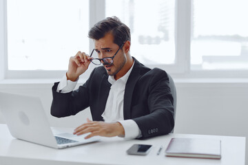 Tired man looking working thinking sitting glasses laptop desk office business