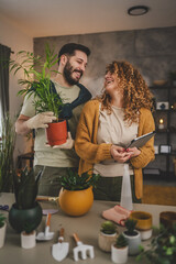 Couple man and woman wife and husband take care of plants at home