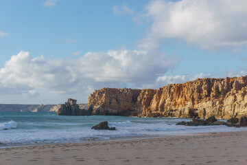 Rock formations in golden sunlight at Praia do Tonel beach, Sagres, Algarve, Portugal