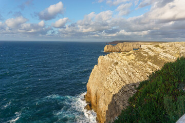 Cliff at the atlantic coast at Cabo Sao Vicente with beautiful clear blue sea water, Sagres,...