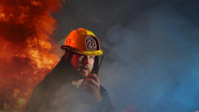 A firefighter communicates on a walkie-talkie during a fire 
