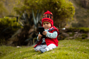 Conexión cultural Bebé con chullo tejido y celular en mano,estilo de vida,aire libre