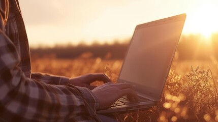 Modern farmer using laptop computer on blurred background with copy space for text