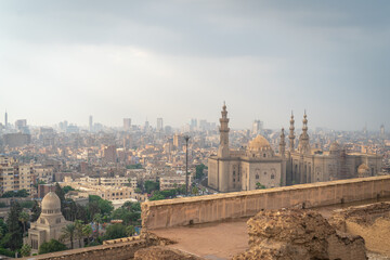 Cairo, Egypt - October 25, 2022. View of the Cairo city and the Mosque-Madrasa of Sultan Hassan from the Mosque of Muhammad Ali in the Citadel.