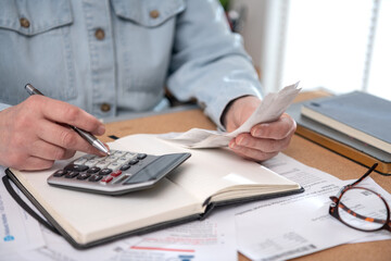 Woman work with financial papers at home count on calculator before paying taxes receipts . woman...