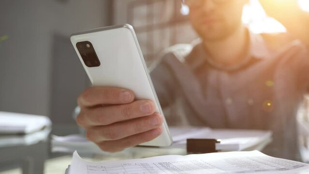 uses smrt phone for making calls or reading news online. Businessman reviews documents