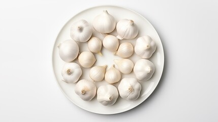 Fototapeta na wymiar Garlic positioned on a white round plate against a white background, seen from the top