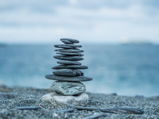 The stacking stones on the beach, representing the believe in Buddhism as in a sign of mediation.
