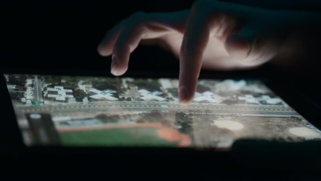 Person navigating a city map using fingers on a tablet. Close up, slow motion. 