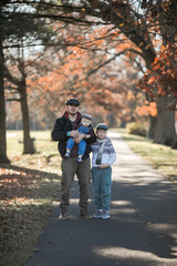 Obraz premium Fathers Day. Brothers and their dad enjoying time together in nature.Candid real family moment.