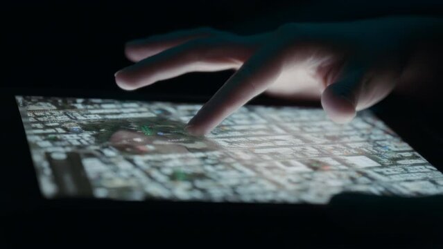 Person moving a satellite view map on a tablet. Close up, slow motion. 
